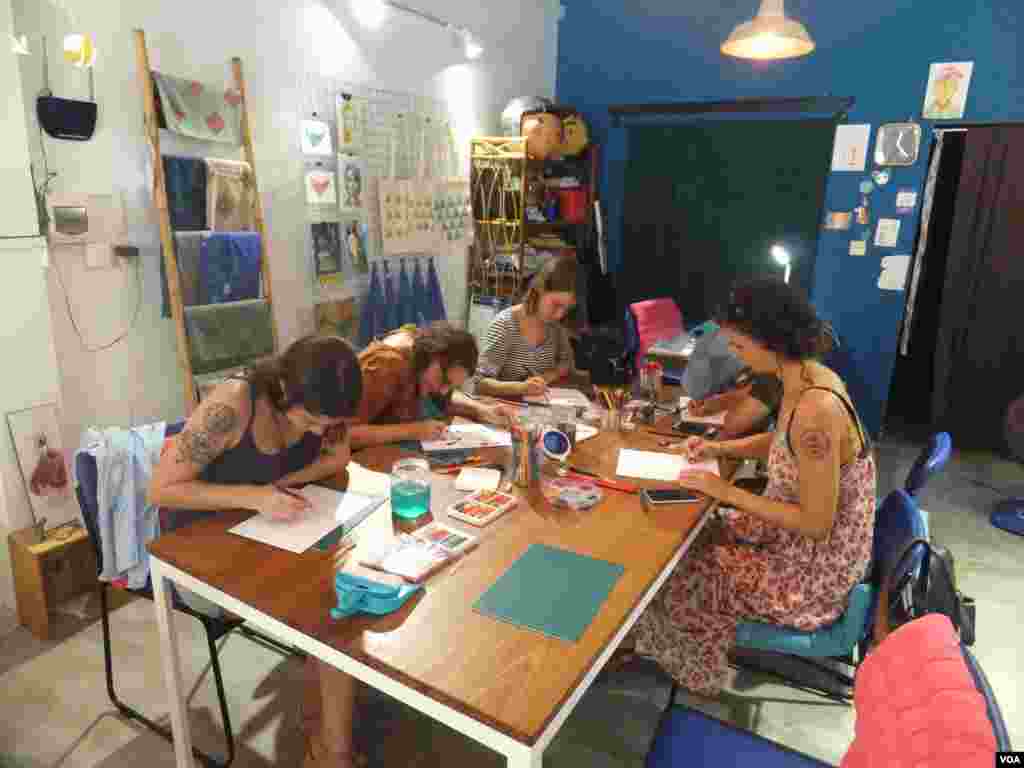 អ្នកចូលរួមក្នុងកម្មវិធី «Muy Dollar Art Exchange» នៅកំពុងត្រៀម និងចាប់ផ្តើមគូរតាមការយល់ឃើញរបស់ខ្លួន នៅវិចិត្រសាល Nowhereនៅក្នុងរាជធានីភ្នំពេញ នៅថ្ងៃទី១១ ខែមិថុនា ឆ្នាំ២០១៦។ (សើ សាយ្យាណា /VOA)