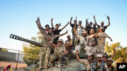 Les forces soutenues par les USA célèbrent la reprise de Syrte, en Libye, au groupe Etat islamique, le jeudi 11 août 2016. Cette ville est le dernier bastion du groupe Etat islamique dans ce pays d'Afrique du Nord. (Albinyan Al Marsous Operation Media Center via AP)