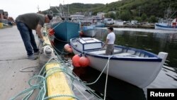 El pescador Ron Bidgood ayuda a amarrar y asegurar los botes en Petty Harbor-Maddox Cove mientras el huracán Larry se acerca a Terranova, Canadá, el 10 de septiembre de 2021. 