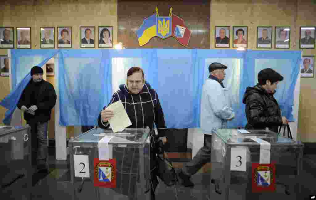 A woman casts her ballot at a polling station during the Crimean referendum, in Sevastopol, Ukraine, March 16, 2014.