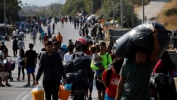 FILE - Migrantë nga kampi i Morias duke u larguar