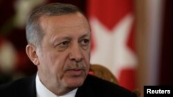 FILE - Turkish President Recep Tayyip Erdogan listens during a news conference in Riga, Oct. 23, 2014. 