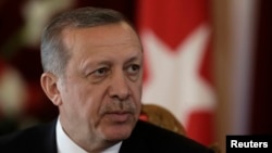 FILE - Turkish President Recep Tayyip Erdogan listens during a news conference in Riga, Oct. 23, 2014. 