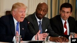 FILE - President Donald Trump, left, speaks during a meeting with manufacturing executives at the White House in Washington, including Merck CEO Kenneth Frazier, center, and Ford CEO Mark Fields, Feb. 23, 2017. 