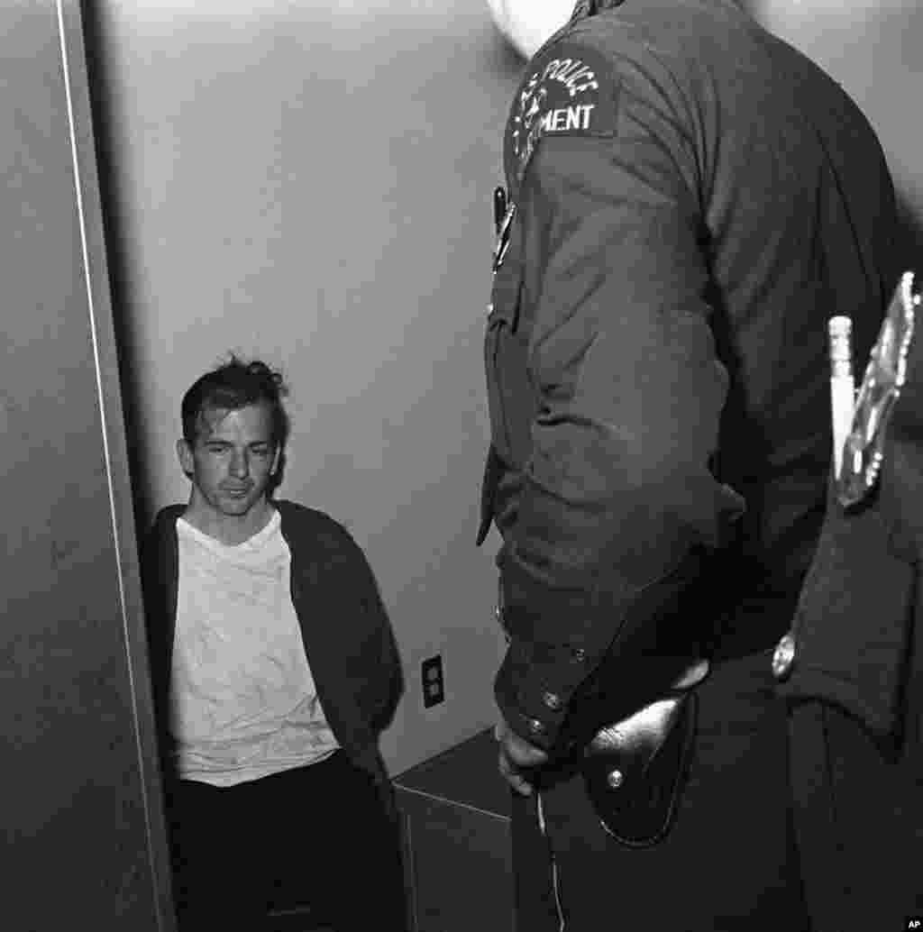 Lee Harvey Oswald en custodia de la policía poco después del asesinato del presidente John F. Kennedy. 