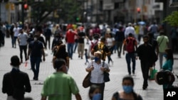 Ciudadanos con tapabocas en medio de la pandemia de coronavirus caminan por el bulevar de Sabana Grande en Caracas, Venezuela. Junio 17, 2020.