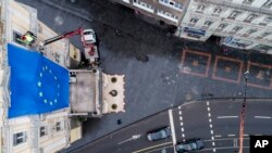 Radnici stavljaju zastavu EU na zgradu u glavnoj ulici u Sarajevu, Bosna, petak, 16. decembra 2022.