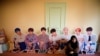 FILE - A fan of K-pop idol boy band BTS poses for photographs with cut-out of BTS at a pop-up store selling BTS goods in Seoul, South Korea, Dec. 24, 2019. 