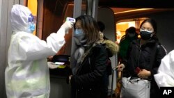 北京检疫人员2020年1月22日在机场测量来自武汉旅客的体温