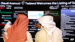 Saudi stock market officials watch the market screen displaying Saudi Arabia's state-owned oil company Aramco after the debut of Aramco's initial public offering (IPO) on the Riyadh's stock market in Riyadh, Saudi Arabia, Dec. 11, 2019. 