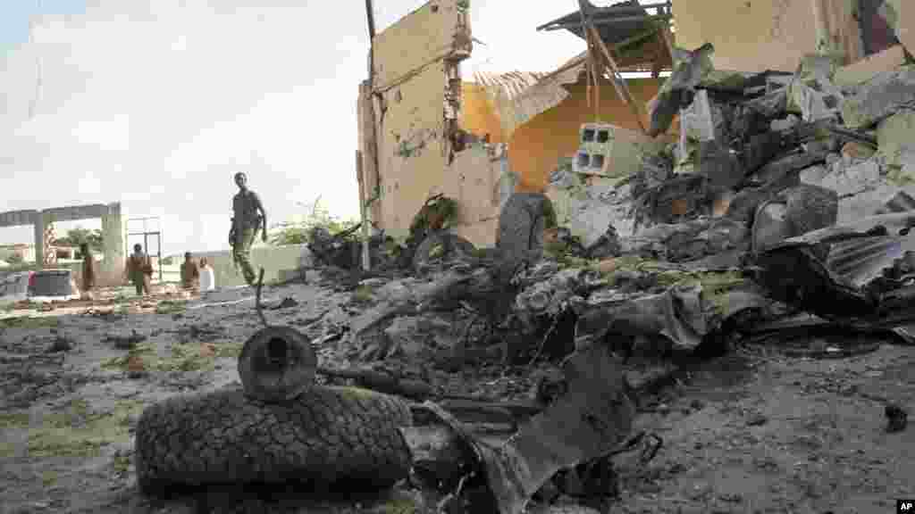 Un soldat somalien observe la scène de l'attentat à la voiture piégée perpétré par Al-Shabaab dans la capitale Mogadiscio, Somalie, 21 juin 2015. 