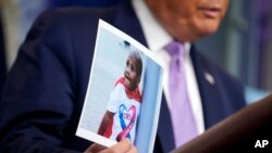 ARHIVA - Predsednik Donald Tramp drži fotografiju četvorogodišnjeg dečaka Ledženda Talifera na konferenciji za novinare u Vašingtonu (Foto: AP)