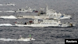 Pesawat pengintai Angkatan Laut China, Haijian No. 66 (tengah) melaju melewati dua kapal penjaga pantai Jepang di sekitar pulau-pulau sengketa di Laut China Timur (foto: dok). 