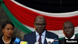 Mwenyekiti wa IEBC Wafula Chebukati (katikati),akihutubia waandishi wa habari katika ukumbi wa Bomas Nairobi, Kenya, Oct. 25, 2017.