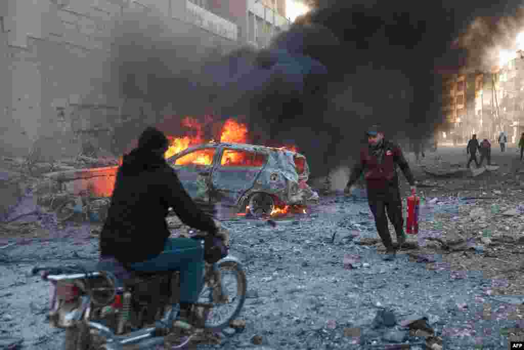 People try to extinguish fires following an airstrike that targeted Syria's rebel-held northern city of Idlib.