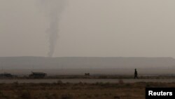 FILE - Smoke rises in Deir al-Zor, Syria Sept. 20, 2017.
