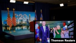 Joe Biden y su esposa, Jill Biden, vistos a través de una pantalla instantes después de conocerse que el exvicepresidente será el candidato demócrata en las elecciones de noviembre.