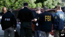 Beberapa agen FBI melakukan penyelidikan di lokasi ledakan bom di Austin, Texas (foto: ilustrasi). FBI menangkap seorang pria yang dituduh mengirim paket-paket mencurigakan ke beberapa fasilitas militer AS. 