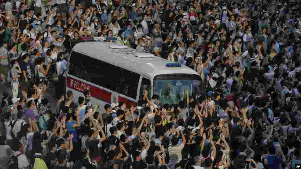 A police car is blocked by protesters after thousands of people block a main road to the financial Central district outside the government headquarters in Hong Kong, Sept. 28, 2014.