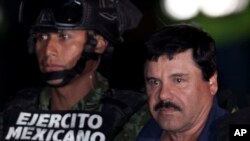 Gembong narkoba Meksiko Joaquin "El Chapo" Guzman, kanan, dikawal oleh tentara dan marinir menuju helikopter, di Mexico City, 8 Januari 2016. 