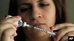 FILE - Judith Garcia fills a syringe as she prepares to give herself an injection of insulin at her home in the Los Angeles suburb of Commerce, Calif., April 29, 2012. The WHO reports diabetes is four times more common than it was in 1980, and now afflicts 422 million adults. 
