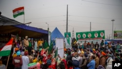 Petani mendengarkan pembicara saat mereka memblokir jalan raya utama dalam aksi protes terhadap UU pertanian di perbatasan negara bagian Delhi-Uttar Pradesh, India, Senin, 4 Januari 2021. 
