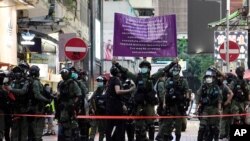 Para petugas kepolisian mengacungkan poster berisi peringatan kepada para demonstran di Hong Kong, Minggu, 6 September 2020. 