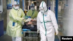 Medicinski radnici u zaštitnim odelima transportuju pacijenta u izolovano krilo u oblasti Kaidian, u Kini, 6. febrara 2020. (Foto: Reuters/China Daily)