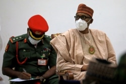 Nigerian President Muhammadu Buhari looks on after security forces rescued schoolboys at the Government house in Katsina, Nigeria, Dec. 18, 2020.