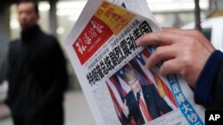 Seorang pria membaca koran dengan laporan utama berjudul "Presiden AS Terpilih Donald Trump Beri Kejutan Besar Pada Amerika" di sebuah kios koran di Beijing (10/11). (AP/Andy Wong)