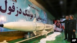 Kepala divisi kedirgantaraan Garda Revolusi Iran, Amir Ali Hajizadeh, kiri, menjelaskan rudan balistik darat ke udara, Dezful, kepada Panglima Garda Revolusi, Mohammad Ali Jafari, dalam sebuah upacara inagurasi di lokasi rahasia (foto: Sepahnews via AP)