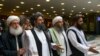 Mullah Abdul Ghani Baradar, pemimpin tertinggi kelompok Taliban (kiri kedua) tiba dengan anggota delegasi Taliban lainnya untuk mengadakan pembicaraan di Moskow, Rusia. (Foto: AP / Alexander Zemlianichenko)
