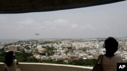 Visitors look out over U.S. Marine Corps Air Station Futenma in Ginowan on Okinawa, Japan, May 3, 2010. The Japanese and U.S. governments want the Futenma Air Base located in the middle of a crowded city moved to a sparsely populated area for safety reaso