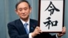 Japan’s Chief Cabinet Secretary Yoshihide Suga unveils the name of new era “Reiwa” at the prime minister’s office in Tokyo, Monday, April 1, 2019. 