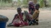 FILE - A woman and children watch as Rwandan soldiers patrol in the village of Mute, in Cabo Delgado province, Mozambique, on Aug. 9, 2021. There has been a surge of new attacks by Islamist militants in Cabo Delgado in early 2024.