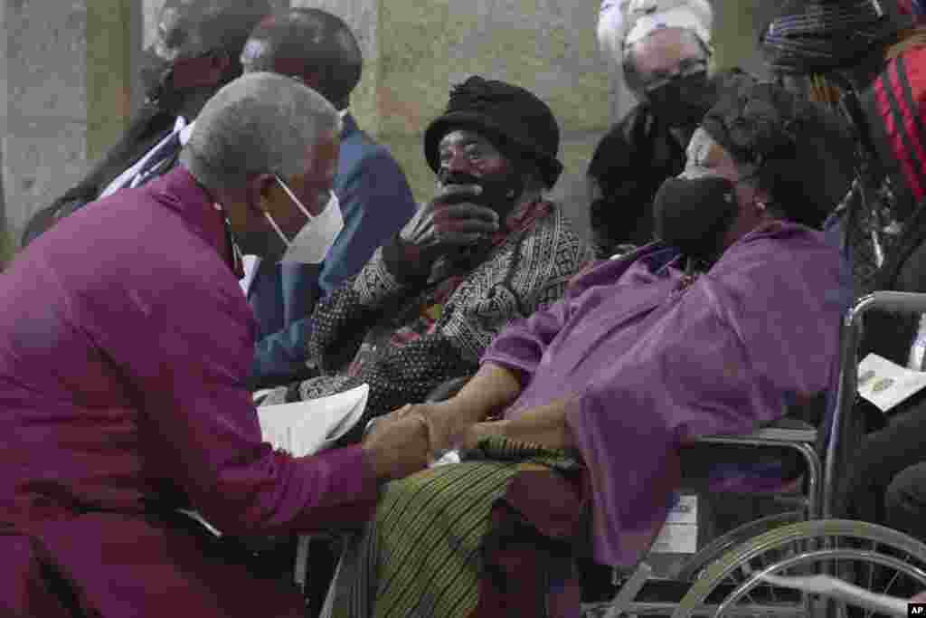 Anglican Archbishop of Cape Town, Thabo Makgoba, left, greets widow Leah Tutu at the funeral of Anglican Archbishop Emeritus Desmond Tutu in St. George's Cathedral in Cape Town, South Africa, Jan. 1, 2022.